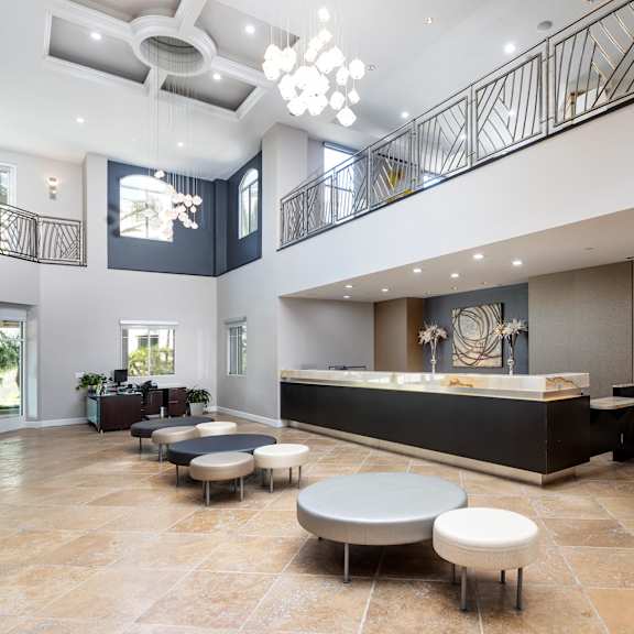 a spacious lobby with a reception desk and seating area. at la jolla crossroads apartments, california