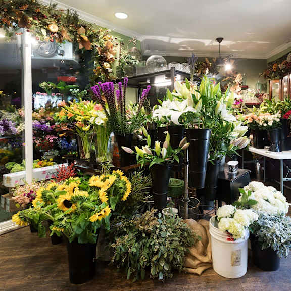 a flower shop with a variety of flowers in different pots and arrangements. at la jolla crossroads apartments, california