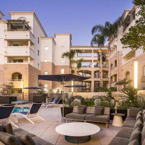 a large building with a pool and lounge chairs. at la jolla crossroads apartments, california, 92122