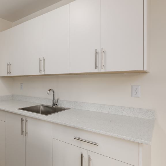 a kitchen with white cabinets and a sink.