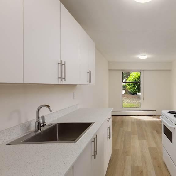 a kitchen with white cabinets and a stove top oven.
