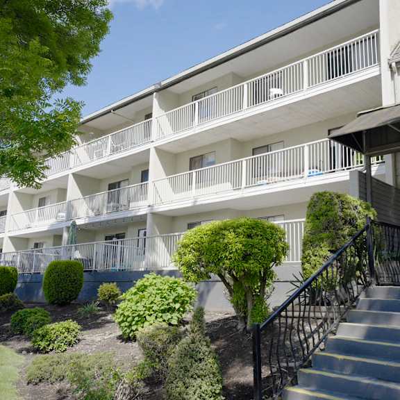 a building with a balcony and stairs leading to the entrance.