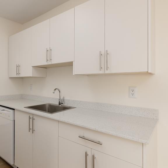 a kitchen with white cabinets and a white sink.