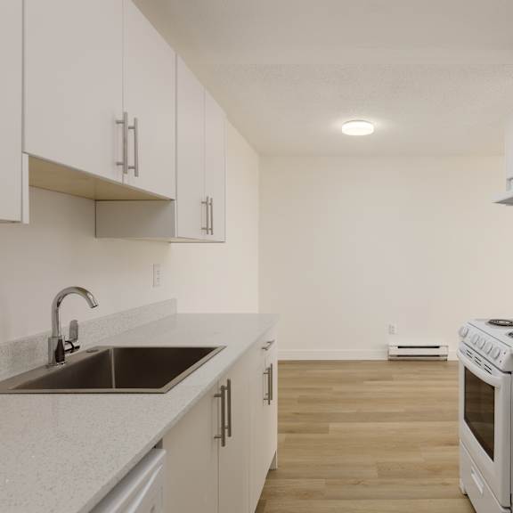 a kitchen with white cabinets and a stove top oven.
