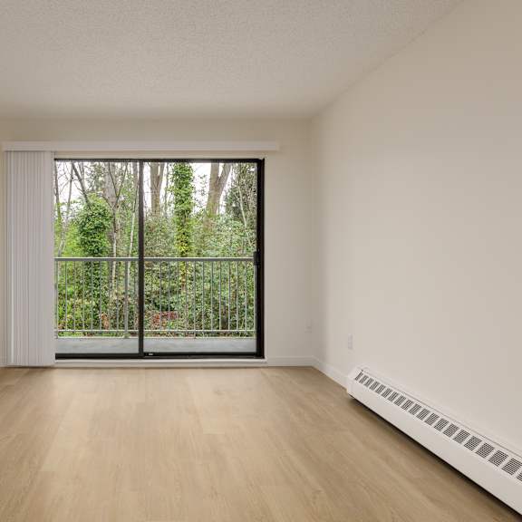 a room with a sliding glass door leading to a garden.