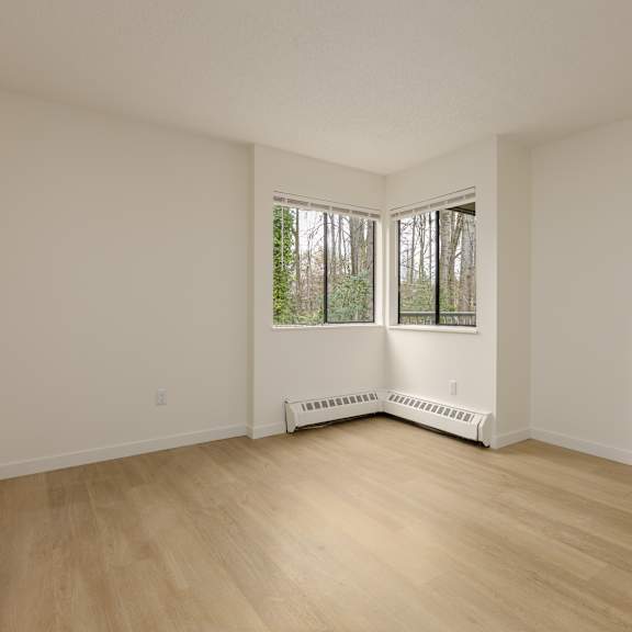 empty room with a window and a radiator on the floor.