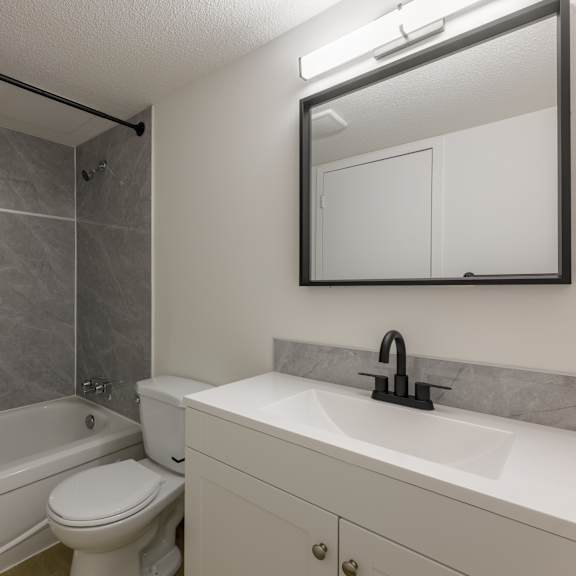 a bathroom with a white toilet and a white sink.