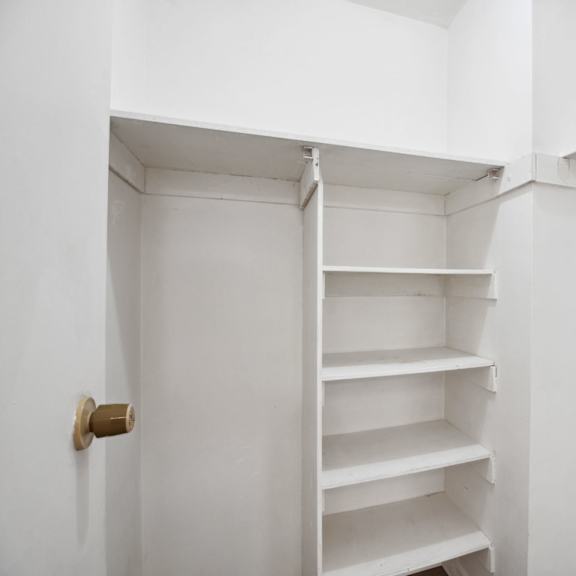 a white shelving unit with a brass door handle.