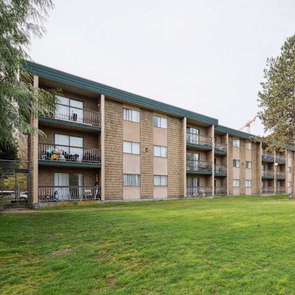 apartment complex with a green lawn in front.