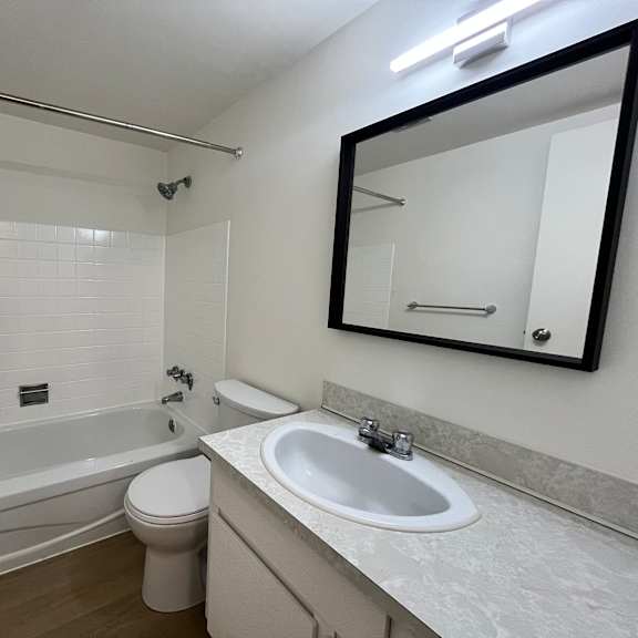 a white bathroom with a tub, toilet, and sink.
