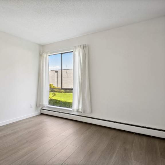 a room with a window overlooking a green lawn.