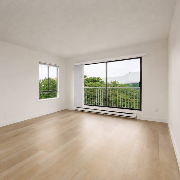 empty room with a window overlooking a green landscape.