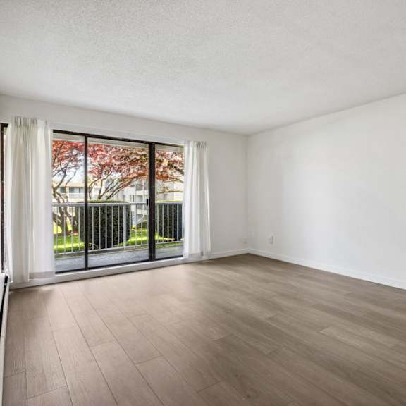 a room with a sliding glass door and wood flooring.