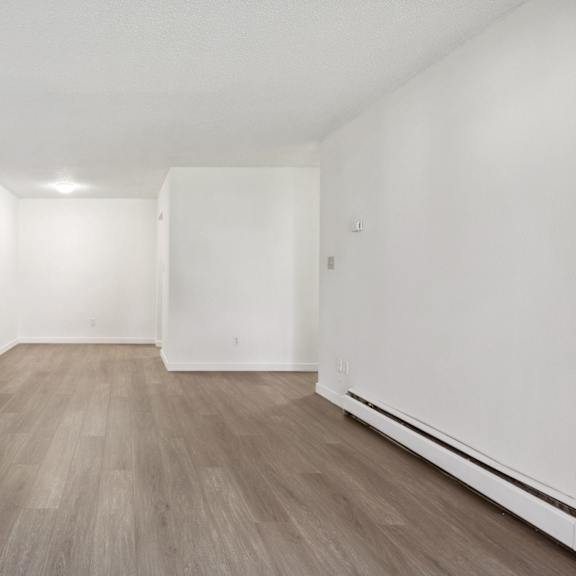 a room with wooden flooring and white walls.