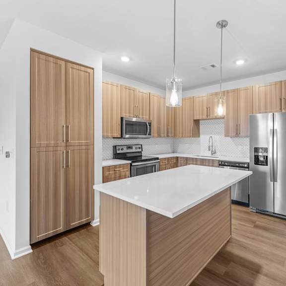 Thumbnail 3 of 6 A modern kitchen with wooden cabinets and stainless steel appliances.