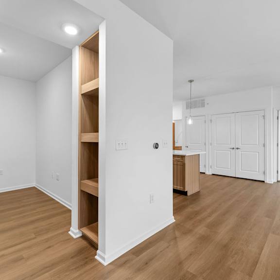 Thumbnail 4 of 6 A room with a white wall and a wooden floor.
