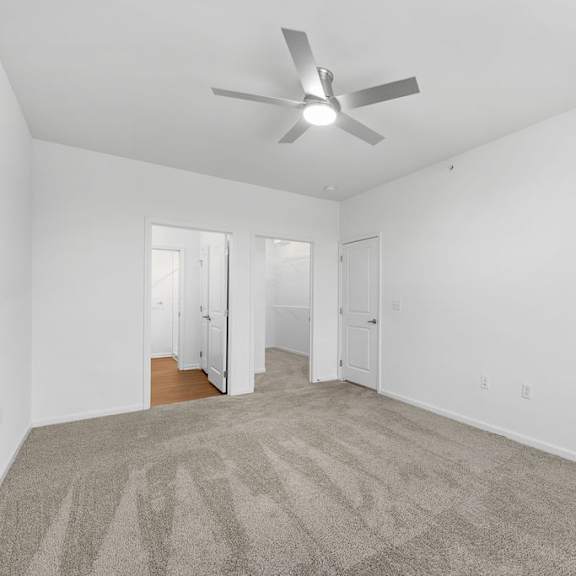 Thumbnail 5 of 6 A room with a ceiling fan and carpeted floor.