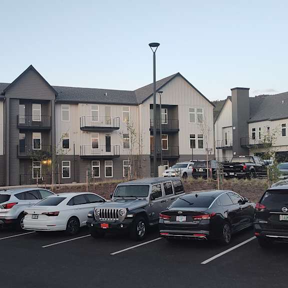 a parking lot full of cars in front of an apartment building