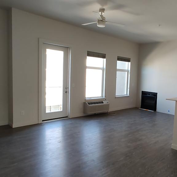 an empty living room with a kitchen