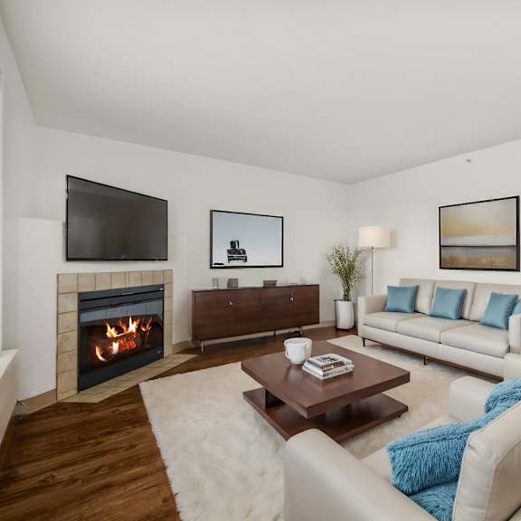 a living room with couches and a coffee table and a fireplace
