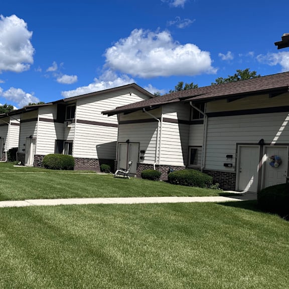 a row of houses with a blue sky and clouds above.