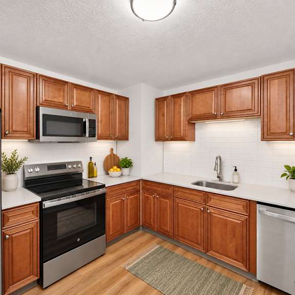 Thumbnail 2 of 8 A kitchen with wooden cabinets and a stainless steel refrigerator.