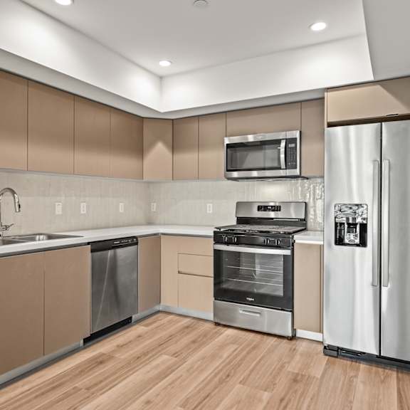 a modern kitchen with wooden floors and stainless steel appliances.