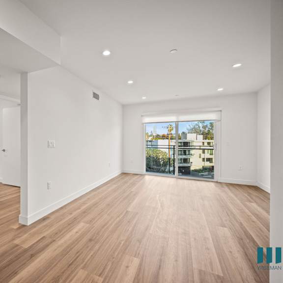 a large empty room with wooden floors and white walls.