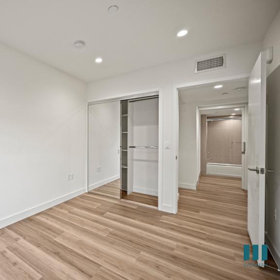 a long hallway with wood floors and white walls.