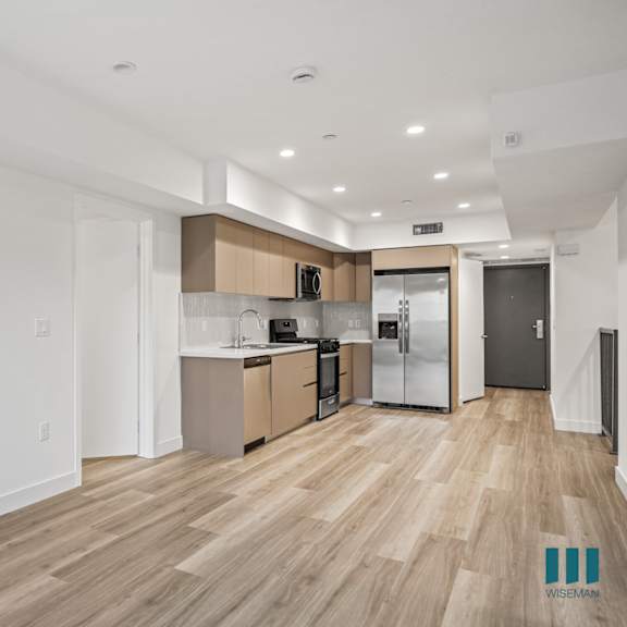 a kitchen with wooden floors and white walls.