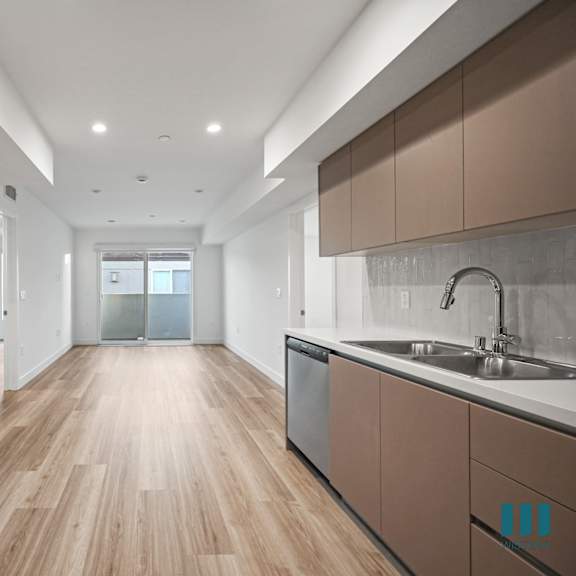 a modern kitchen with wooden floors and white walls.