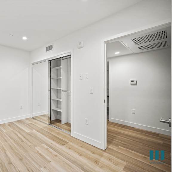a room with a wooden floor and white walls.