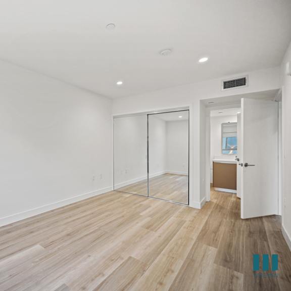 a room with wooden flooring and white walls.