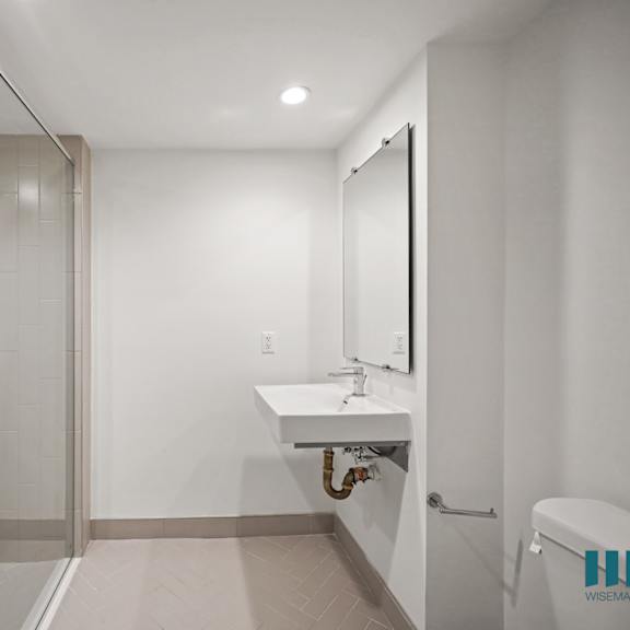 a bathroom with a white sink and a glass shower stall.