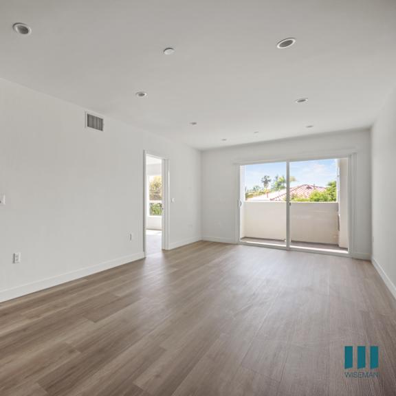 an empty living room with white walls and wooden floors