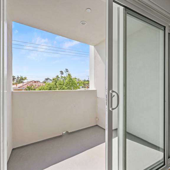 a balcony with a view of a blue sky and a window
