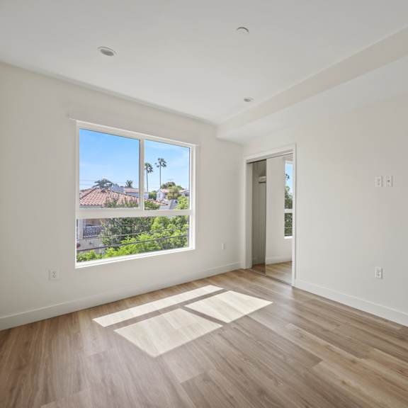 a view of a room with white walls and wood floors
