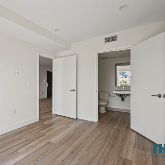 an empty living room with white walls and wood floors