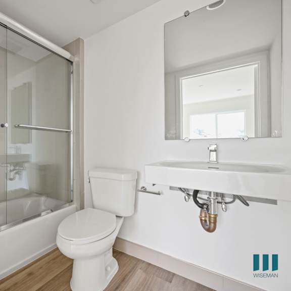 a bathroom with a toilet and a shower and a sink