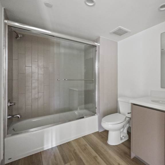 a bathroom with a shower and a sink and a toilet