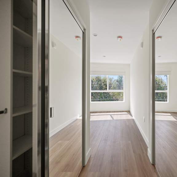 a view of a living room from a hallway with mirrored doors