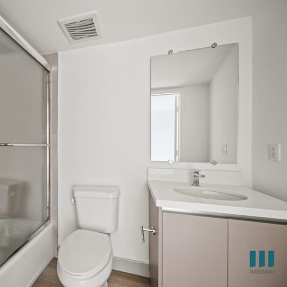 a white bathroom with a shower toilet and sink