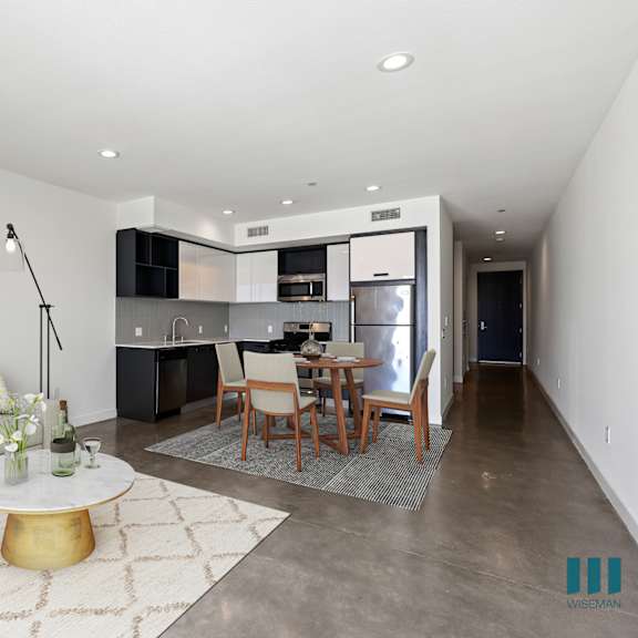 open-concept kitchen, dining, and living room space with concrete flooring