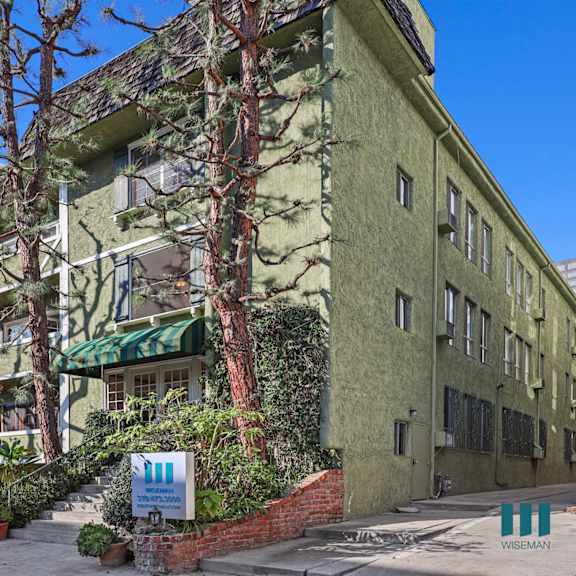 a green building with a sign that says wiseman in front of it.