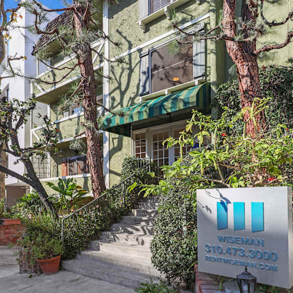 a green building with a sign in front that says "wise 310.473.3000".