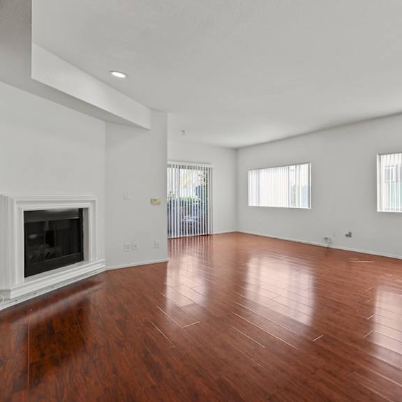 a living room with wood floors and a fireplace