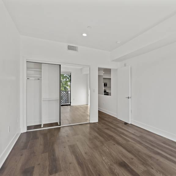 bedroom with mirrored closet, recessed lighting, and vinyl flooring