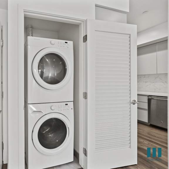 in-suite washer & dryer and hall closet with built-in shelving