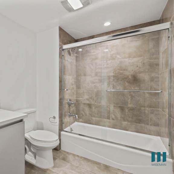 bathroom with shower bath with glass door and vanity cabinet storage