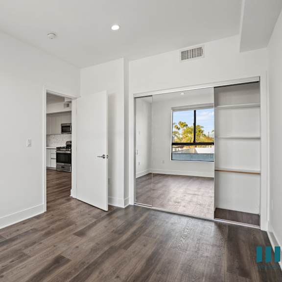 bedroom with mirrored closet with built-in shelving